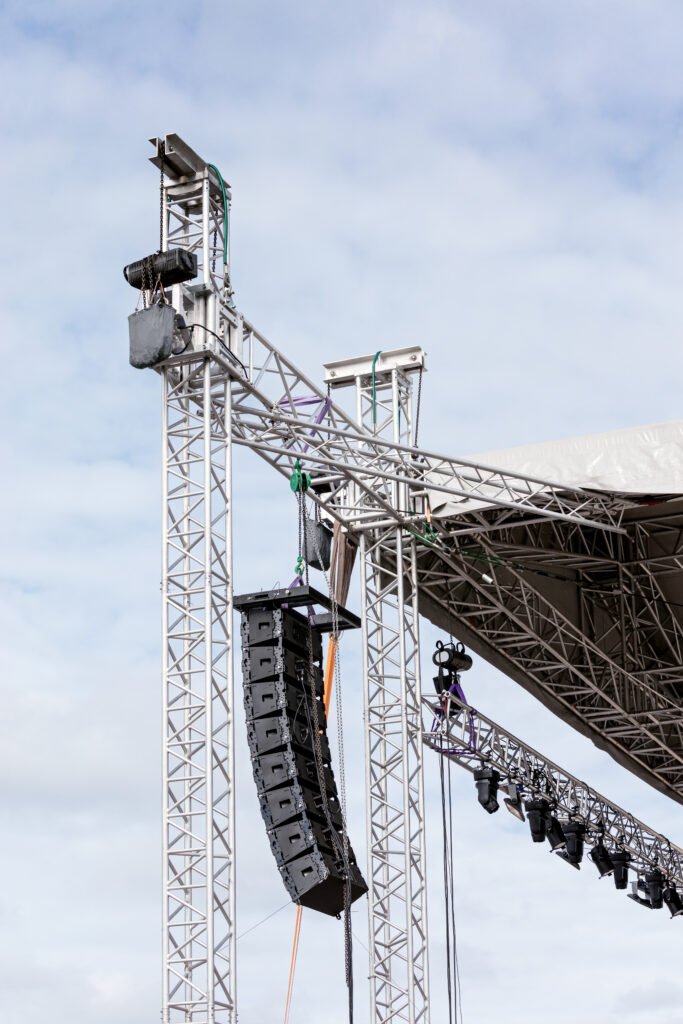 speakers and spotlights equipment mounted on stage against sky background
